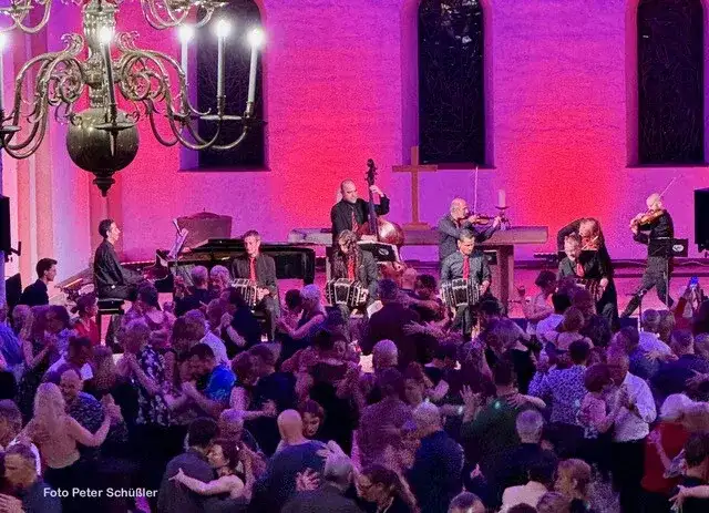 Volle Tanzfläche bei der Noche de 22 Estrellas 2024 in der Kulturkirche — das Orchester spielt, Paare tanzen