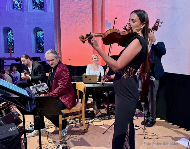 Musiker:innen spielen vor den Bleiglasfenstern der Kulturkirche St. Stephani